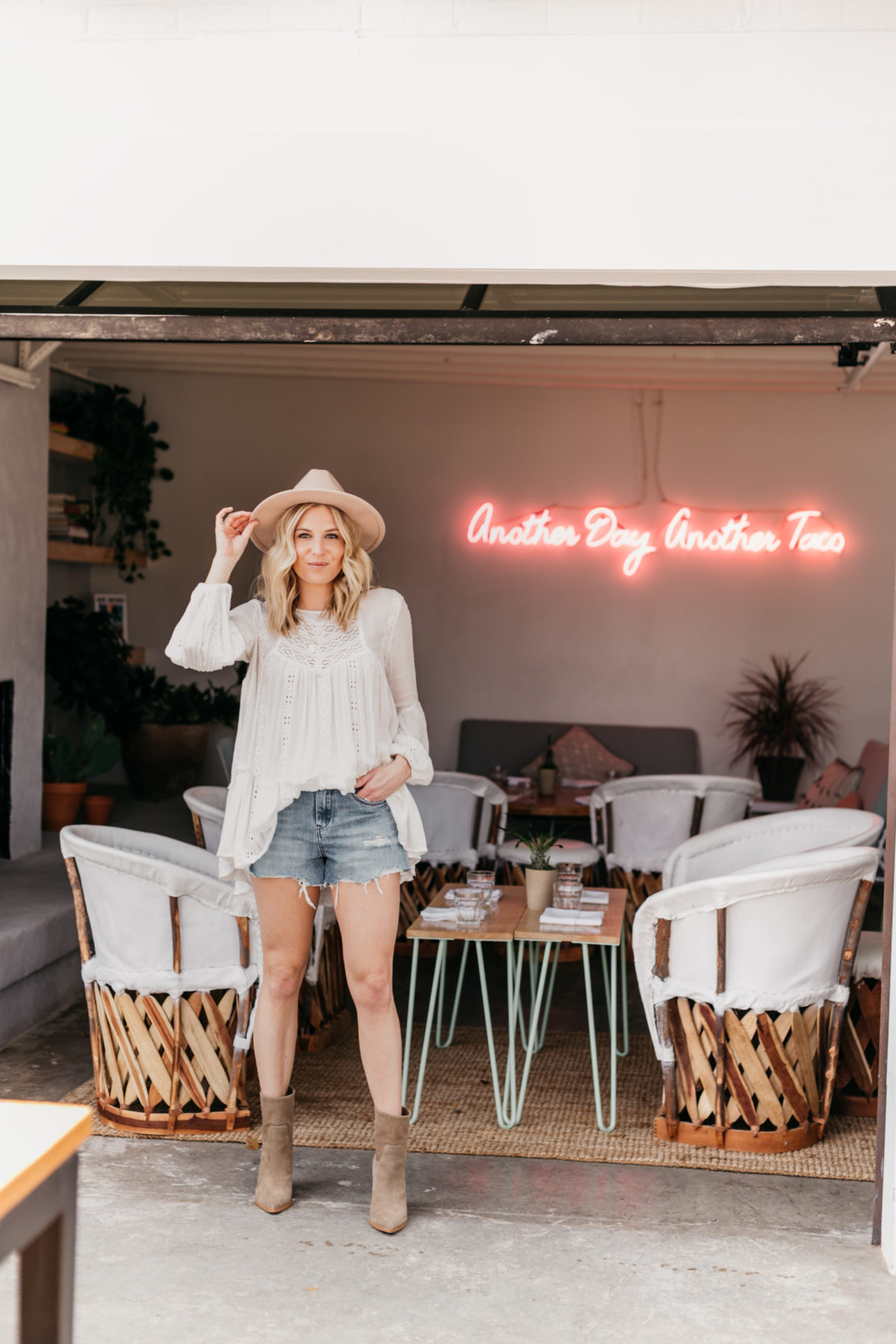 white top, jeans shorts, hat and boots outfit